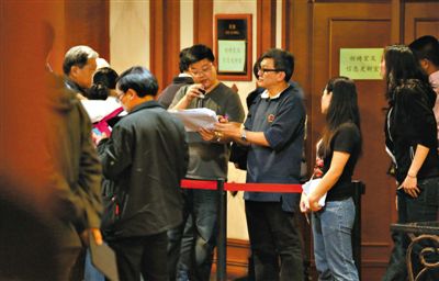 12日，北京麗都飯店，馬航工作人員叫乘客家屬進(jìn)屋領(lǐng)取慰問(wèn)金。目前，馬航兩次向乘客家屬發(fā)放慰問(wèn)金，但未啟動(dòng)賠償。新京報(bào)記者